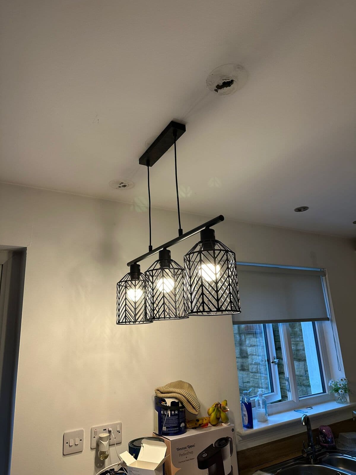 Three-cage pendant light hung over a dining area