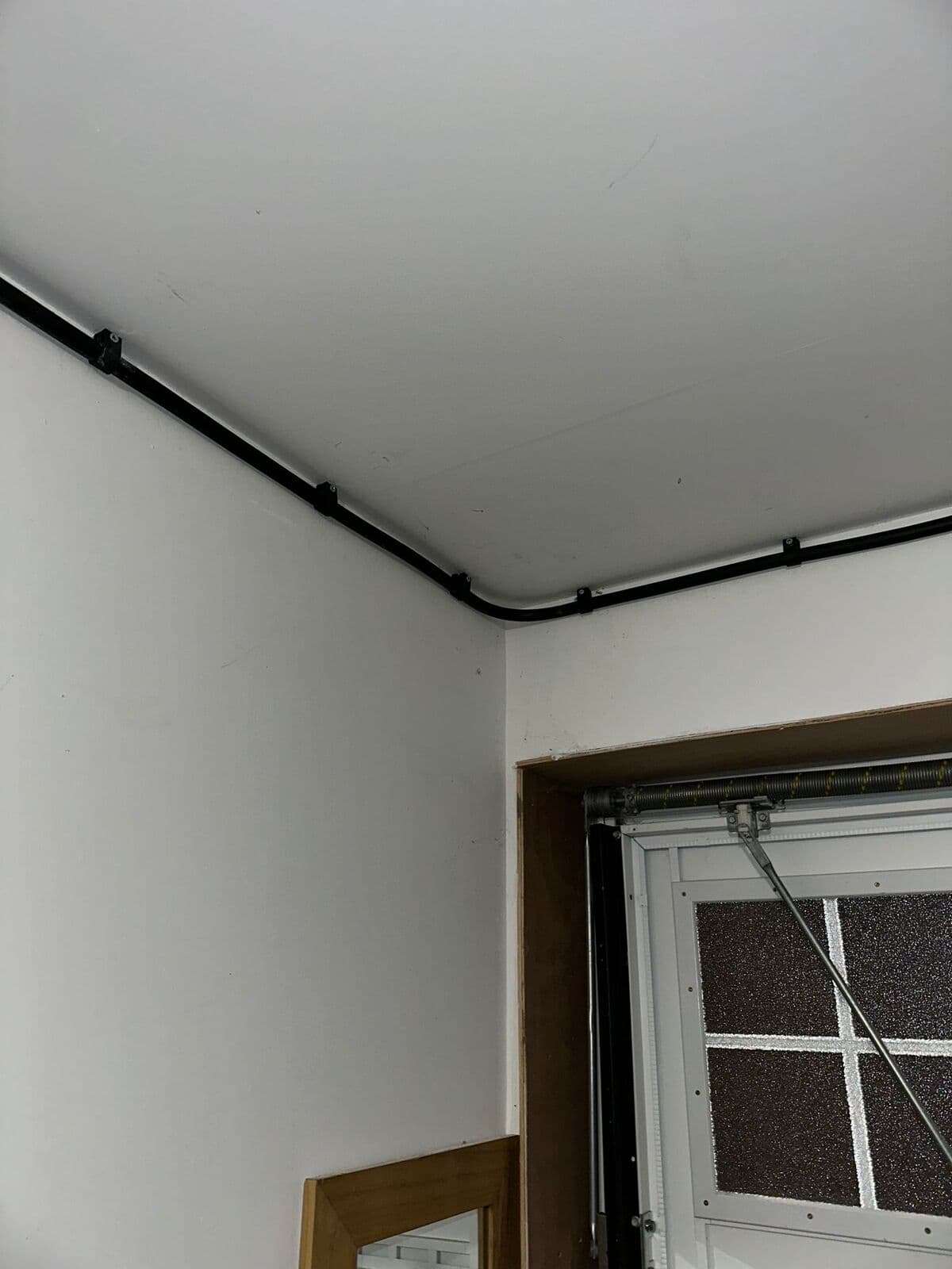 Neat black conduit run along a garage ceiling