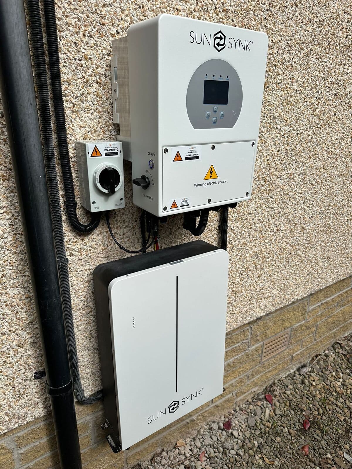 Sunsynk inverter and battery fitted on a rendered wall