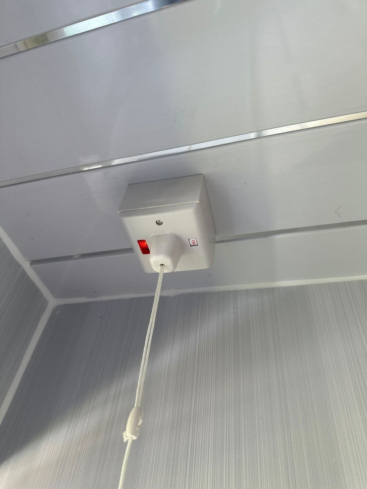 New pull-cord switch fitted on a bathroom ceiling